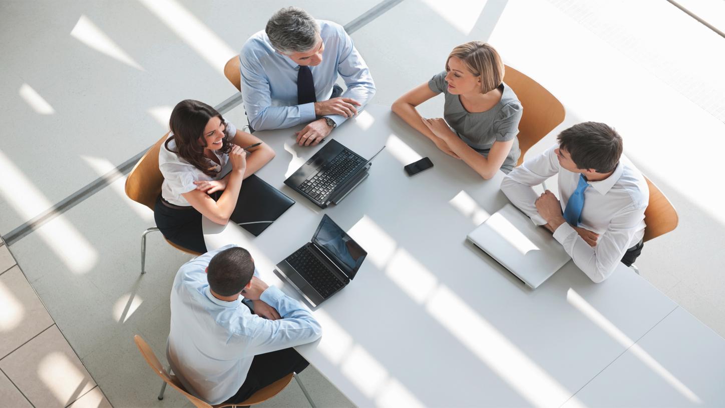 Community diagnostic centres - a group of people are gathered around a long table and discussing a project