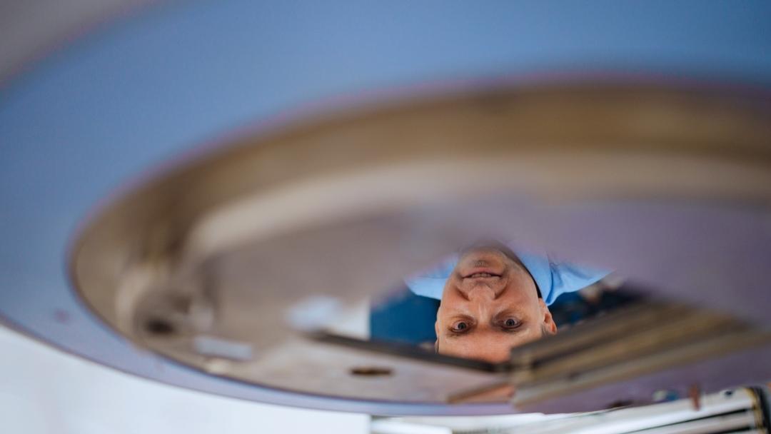 Close up of the beam collimator of the radiotherapy device. Adam Strzelecki is shown in the reflection.