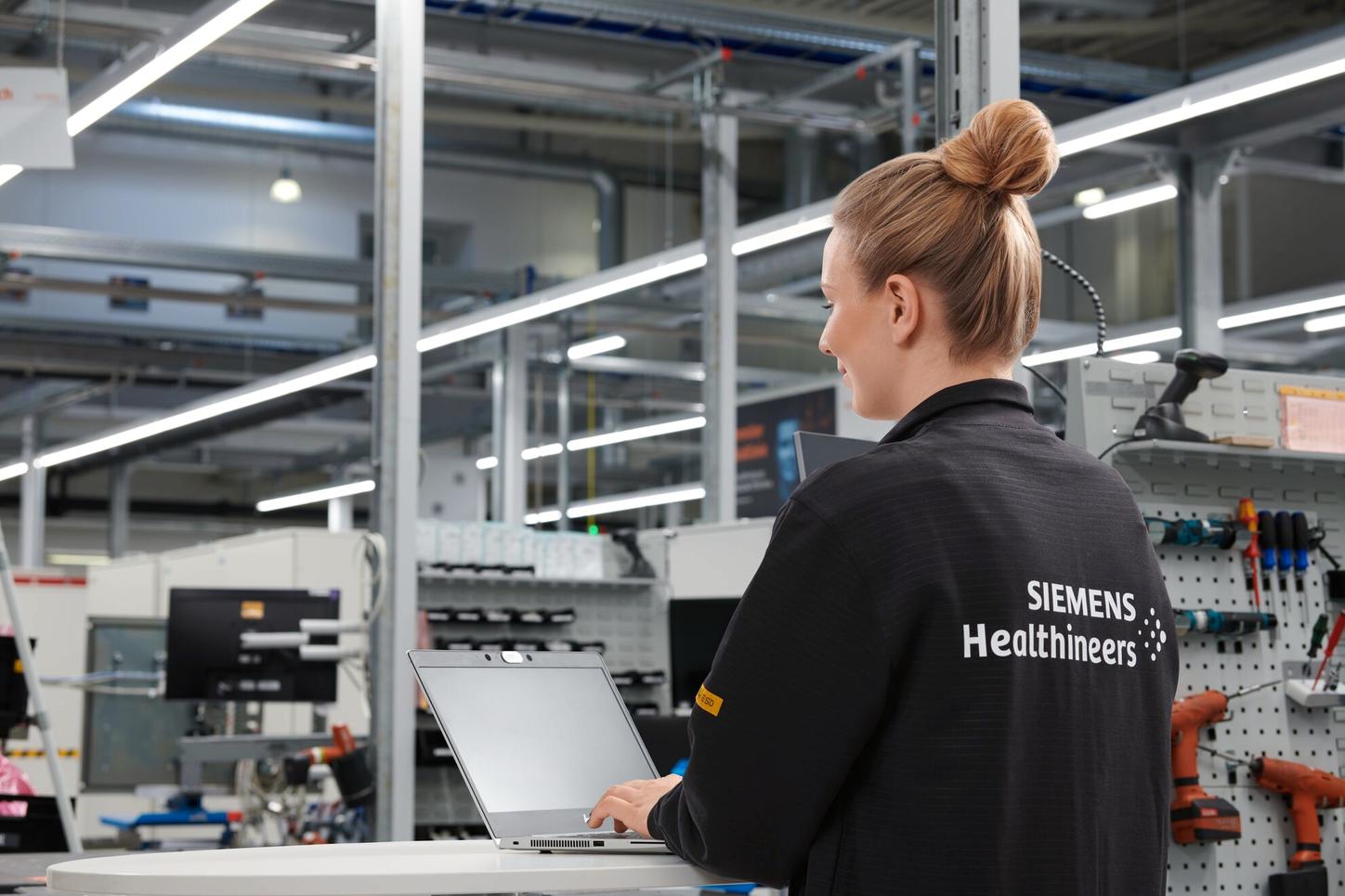 Working student is working on her laptop in the production environment