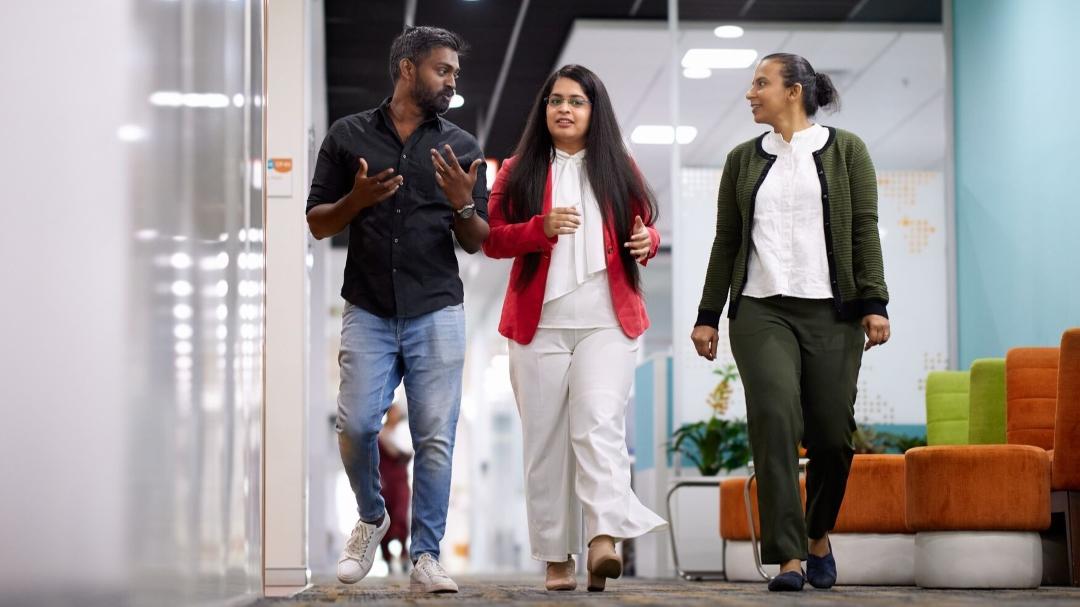 Colleagues walking down office hall way