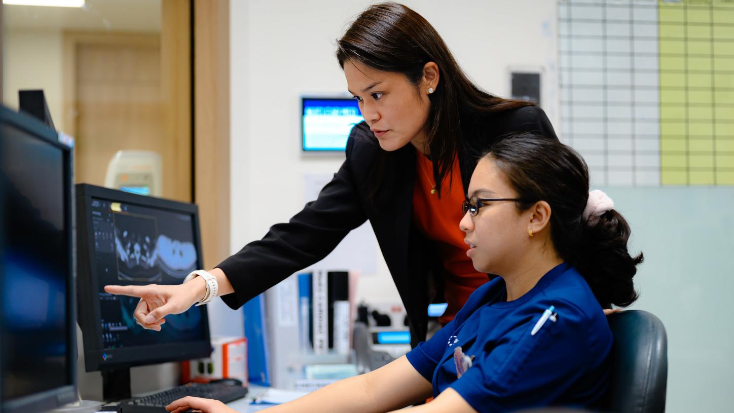 Two healthcare professionals looking at a screen.