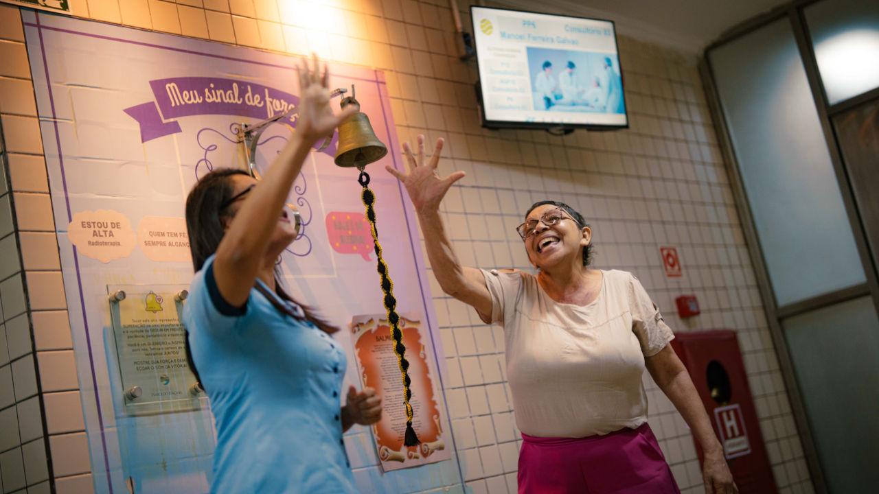 women ringing bell to celebrate that they are cancer free