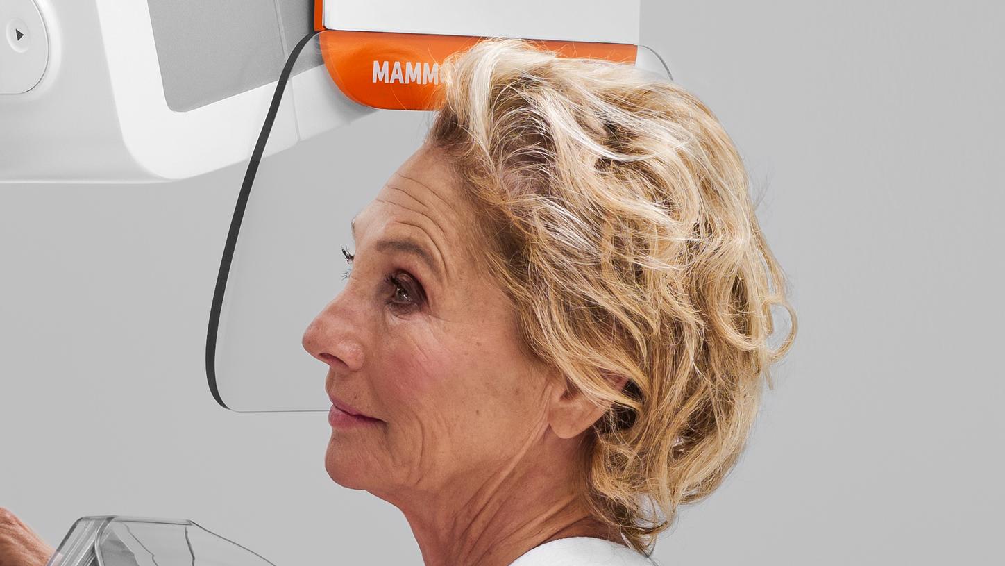 The patient rests her head on the MAMMOMAT B.brilliant's transparent face shield during the scan.
