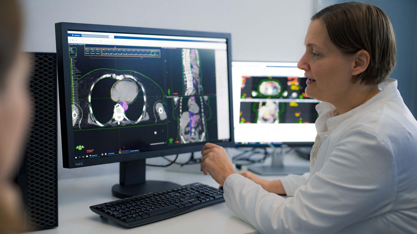 Physicist Vanda Leipold showing clinical images of a cancer case on her screen.